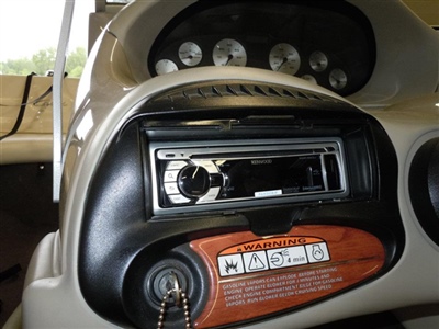  A close-up view of a vehicle's dashboard showing an empty slot where a stereo system would be installed, with gauges visible in the background.